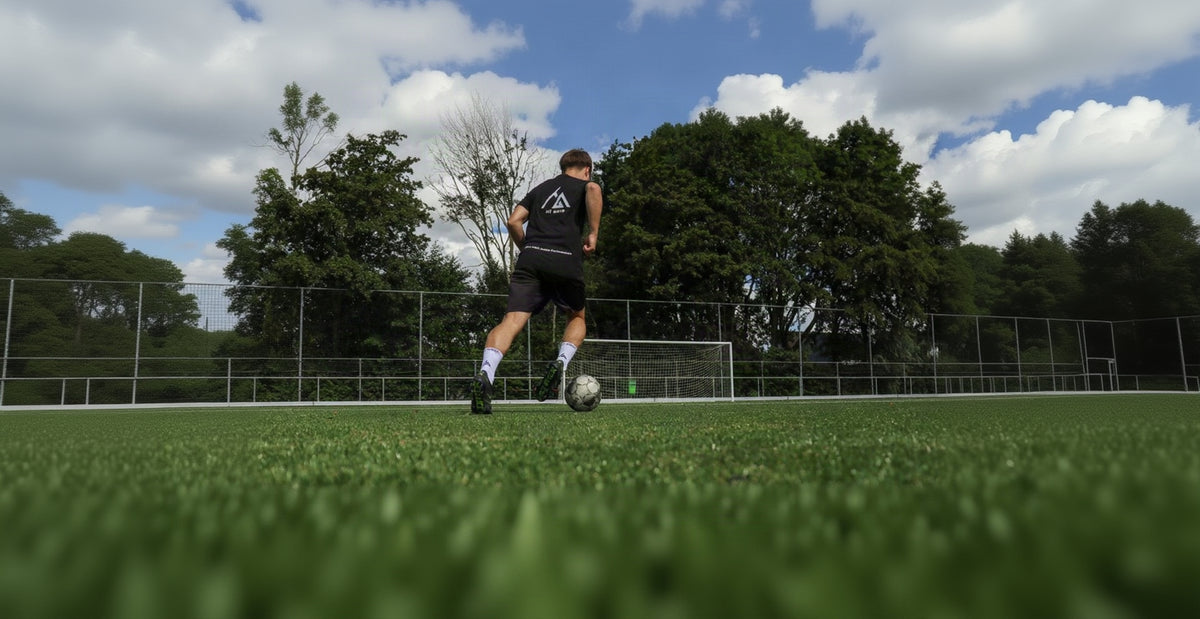 Voetballer op kunstgras, witte gripsokken met grippatroon onder de zool