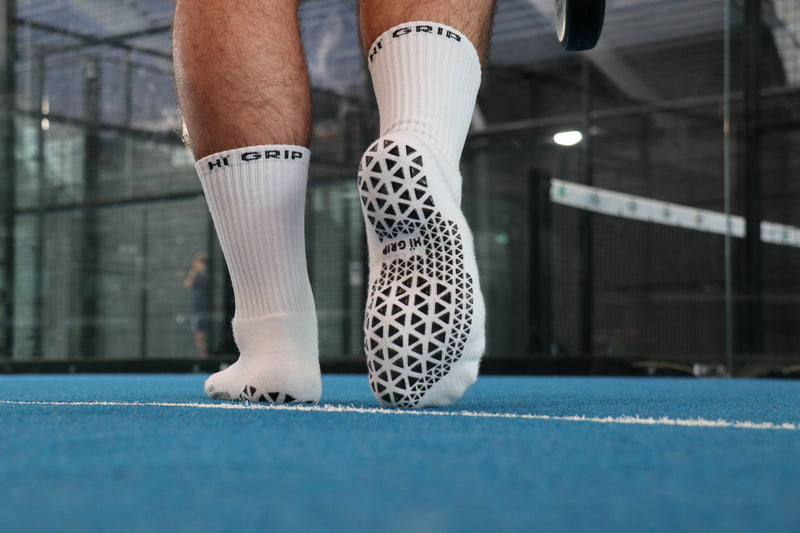 Close-up van padelschoen — voet glijdt weg zonder gripsokken