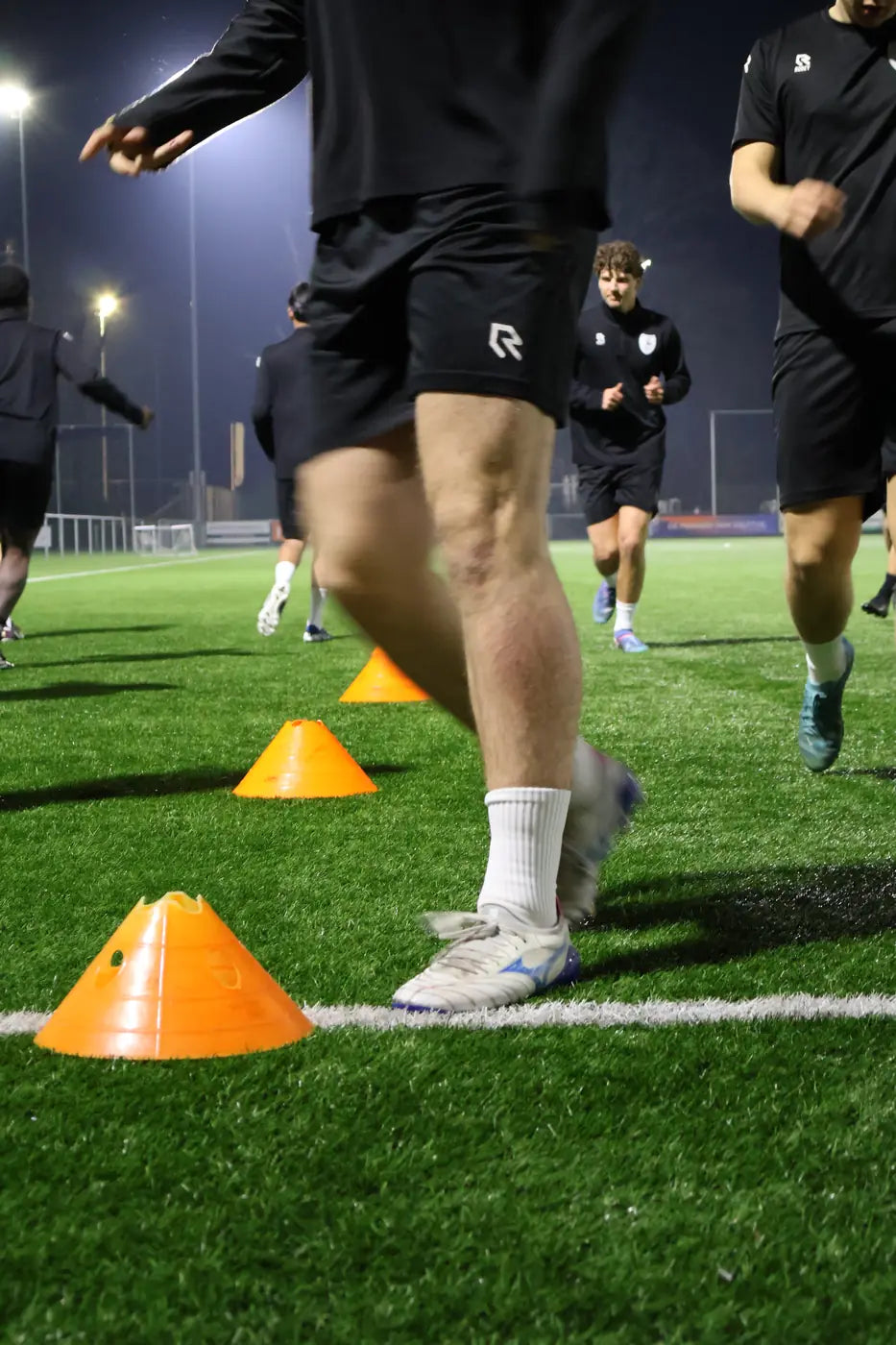 Benen van spelers tussen pionnen tijdens de warming-up