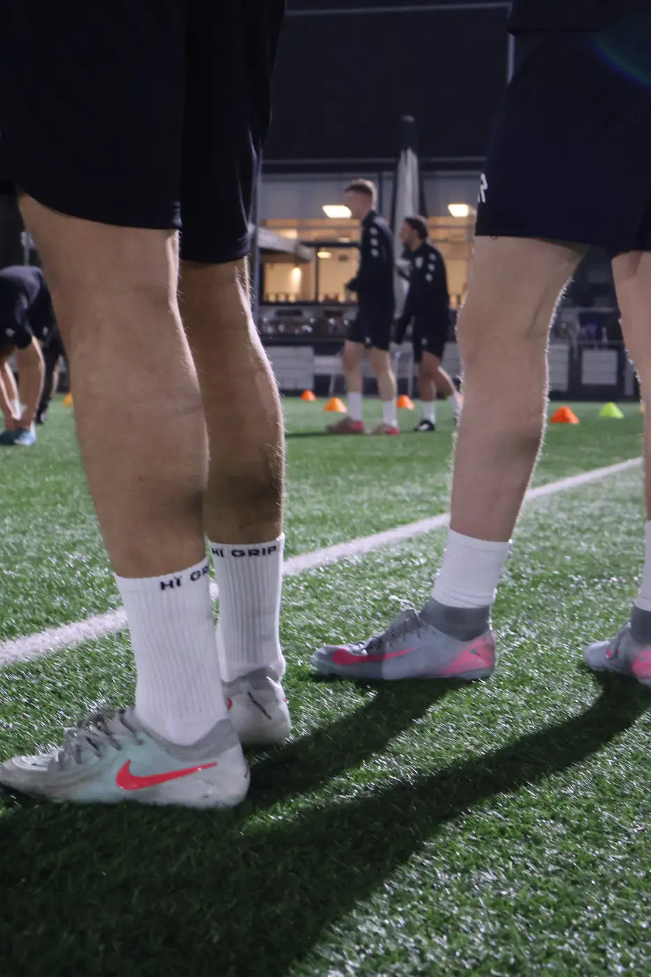 Witte HÏ Grip gripsokken in voetbalschoenen op kunstgras